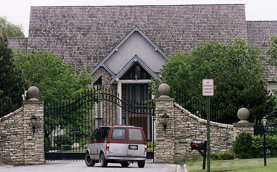 FILE - A van is seen outside the gate at the home of Grammy-winning singer R. Kelly on June 5, 2002, in Olympia Fields, Ill. Crain's Chicago Business reported that a $2.9 million foreclosure was filed by JPMorgan Chase bank against Kelly's suburban Chicago mansion. The 54-year-old R&B singer will once again head to court this week. His federal trial in New York begins Wednesday, Aug. 18. 2021, and will explore years of sexual abuse allegations. He has vehemently denied the allegations against him. (AP Photo/Frank Polich, File)