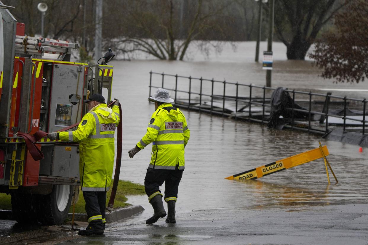 Members of local fire brigade work at a flooded sports venue in Camden on the outskirts of Sydney, Australia, Monday, July 4, 2022.