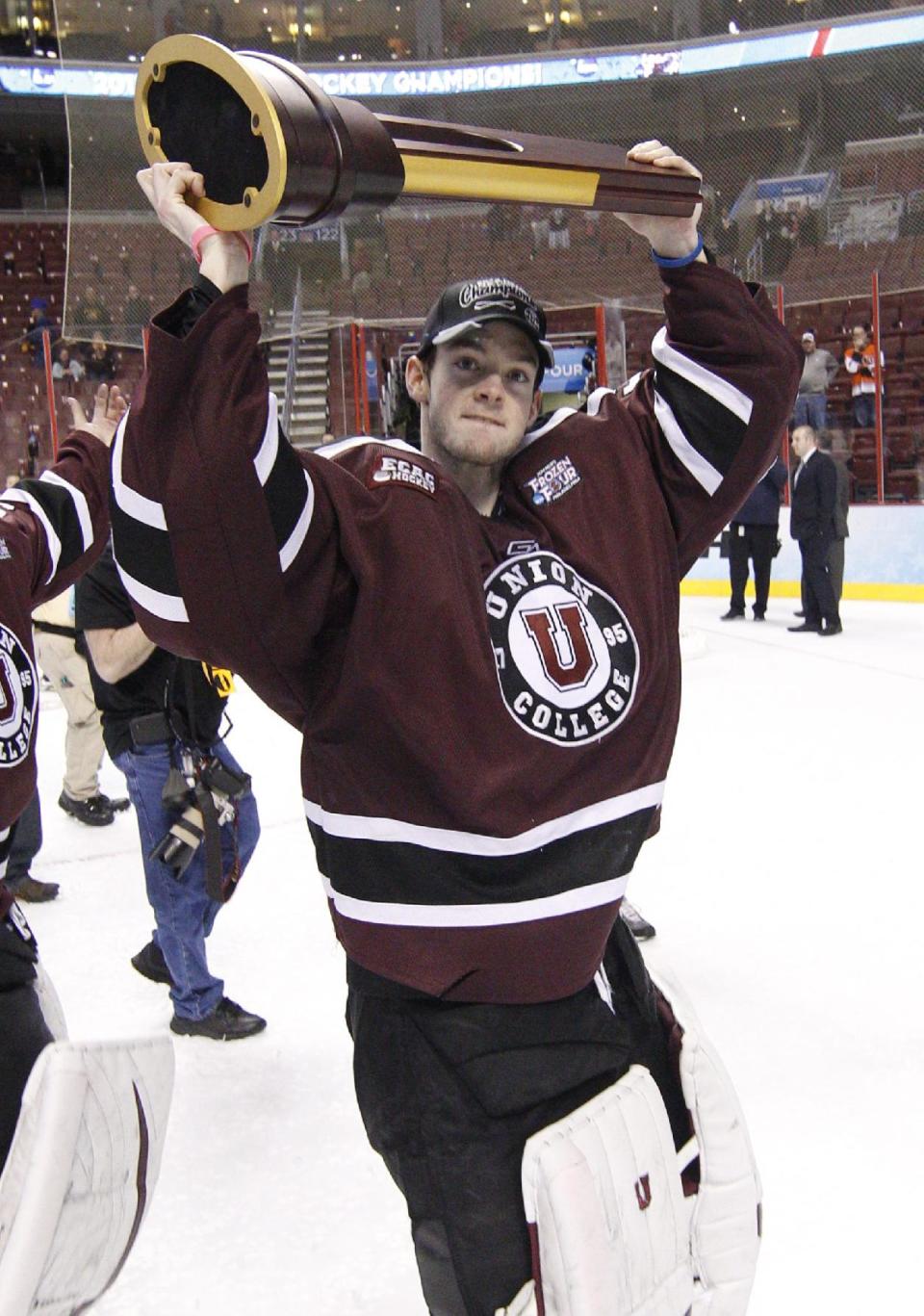 Union's Colin Stevens holds up the championship trophy following an NCAA men's college hockey Frozen Four tournament game against Minnesota, Saturday, April 12, 2014, in Philadelphia. Union won 7-4. (AP Photo/Chris Szagola)