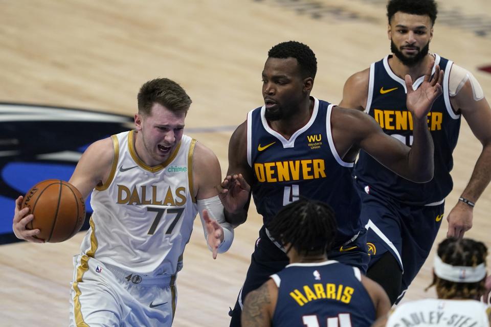 Dallas Mavericks' Luka Doncic (77) moves to the basket against Denver Nuggets guard Gary Harris, bottom center, Paul Millsap (4) and Jamal Murray, right, in the first half of an NBA basketball game in Dallas, Monday, Jan. 25, 2021. (AP Photo/Tony Gutierrez)