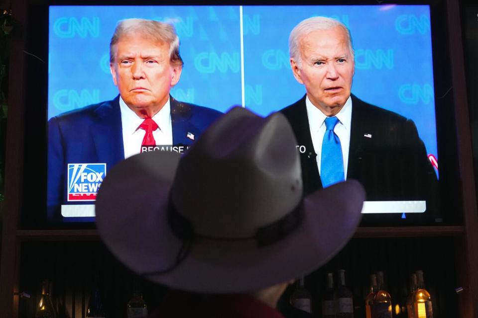 Roger Strassburg, of Scottsdale, Ariz., wears a cowboy hat as he watches the presidential debate