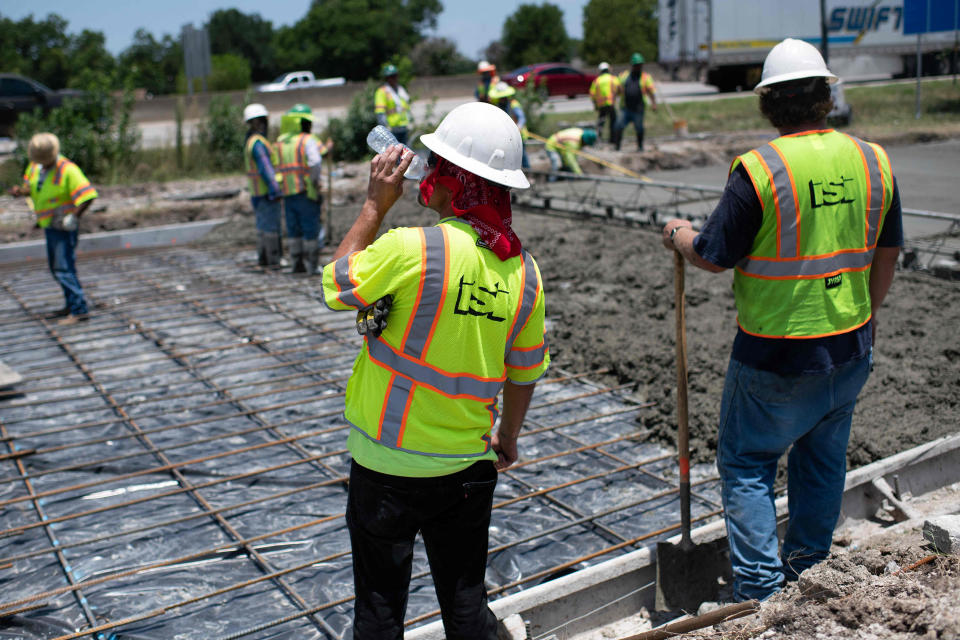 A construction worker takes a sip of water while repairing a road that was damaged from the heat in Houston on June 27, 2023. (Mark Felix / AFP - Getty Images)