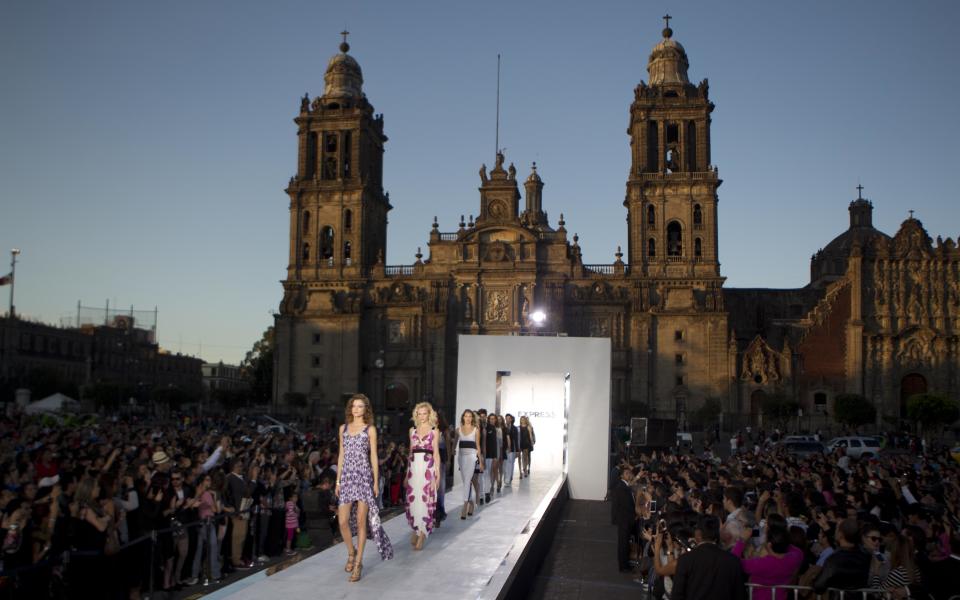 Backdropped by the Metropolitan Cathedral, models wear creations from Express during the "Rock The Sidewalk," event on the final day of the Mercedes Benz Fashion Week, in Mexico City's Zocalo or main plaza, Friday, Nov. 16, 2012. (AP Photo/Eduardo Verdugo)