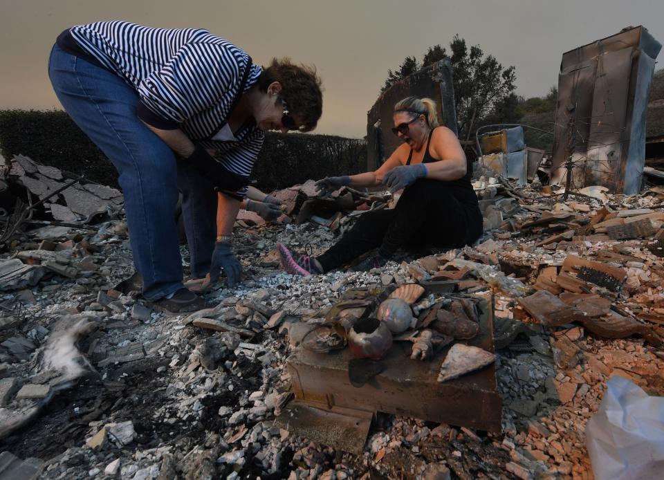 <p>Members of the Reinhardt family sort through the remains of their family home after the Thomas wildfire swept through Ventura, California on Dec. 6, 2017. (Photo: Mark Ralston/AFP/Getty Images) </p>