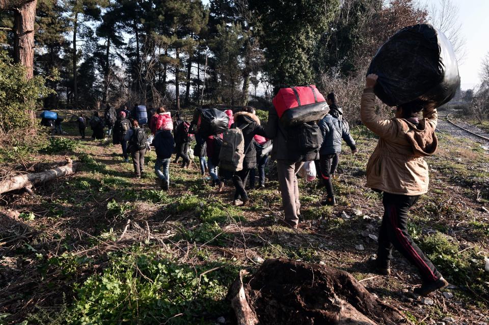 A group of Yazidis from Iraq carrying their few belongings arrive at the makeshift camp.