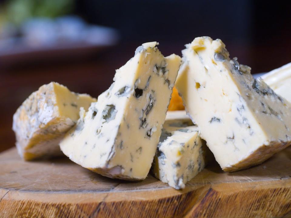 triangles of blue cheese on a wood board