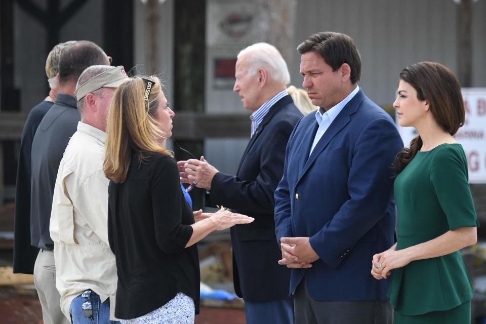 (L-R) US President Joe Biden, Florida Governor Ron DeSantis, and his wife Casey DeSantis speak with local residents impacted by Hurricane Ian at Fishermans Pass in Fort Myers, Florida, on October 5, 2022.