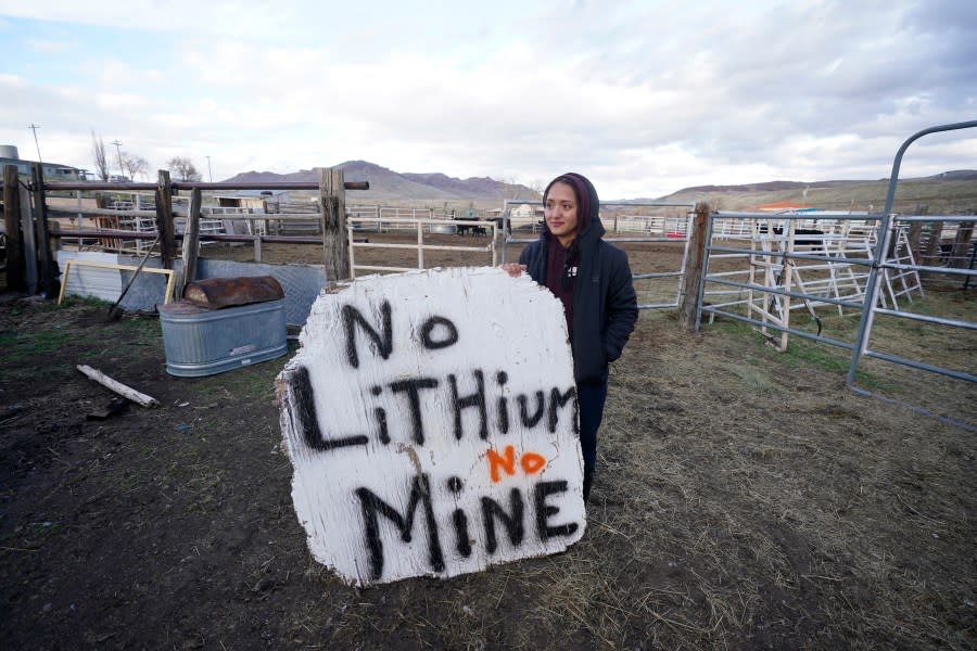 Daranda Hinkey, a Fort McDermitt Paiute and Shoshone tribe member, holds a large hand-painted sign that says “No Lithium No mine” at her home, on April 24, 2023, on the Fort McDermitt Indian Reservation, near McDermitt, Nev. (AP Photo/Rick Bowmer)