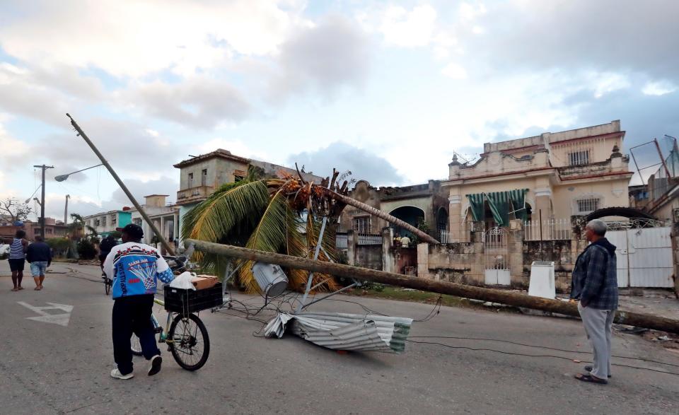 AME4766. LA HABANA (CUBA), 28/01/2019.- Vecinos caminan por una calle afectada por un tornado, este lunes, en La Habana (Cuba). Al menos tres personas han muerto y 172 han resultado heridas por un tornado que azotó esta madrugada la barriada de Regla, en La Habana, informó hoy el presidente de Cuba, Miguel Díaz-Canel. EFE/Ernesto Mastrascusa