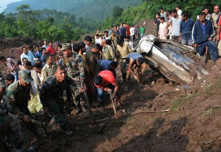 Indian army personnel and rescue workers search for survivors amid the rubble after a landslide caused by a cloudburst swept two buses off the road into a gorge, in Mandi district, in Himachal Pradesh, India, August 13, 2017. REUTERS/Stringer