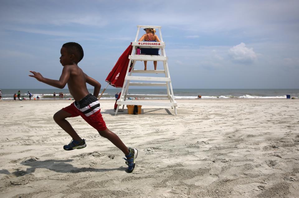 A boy runs past a lifeguard stand while enjoying Huntington Beach State Park on July 14, 2015 in Murrells Inlet, South Carolina.