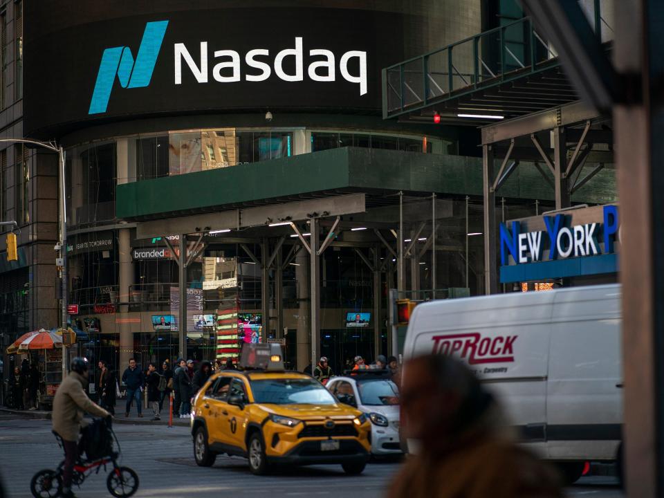 People walk near the Nasdaq building in Times Square on January 24, 2023