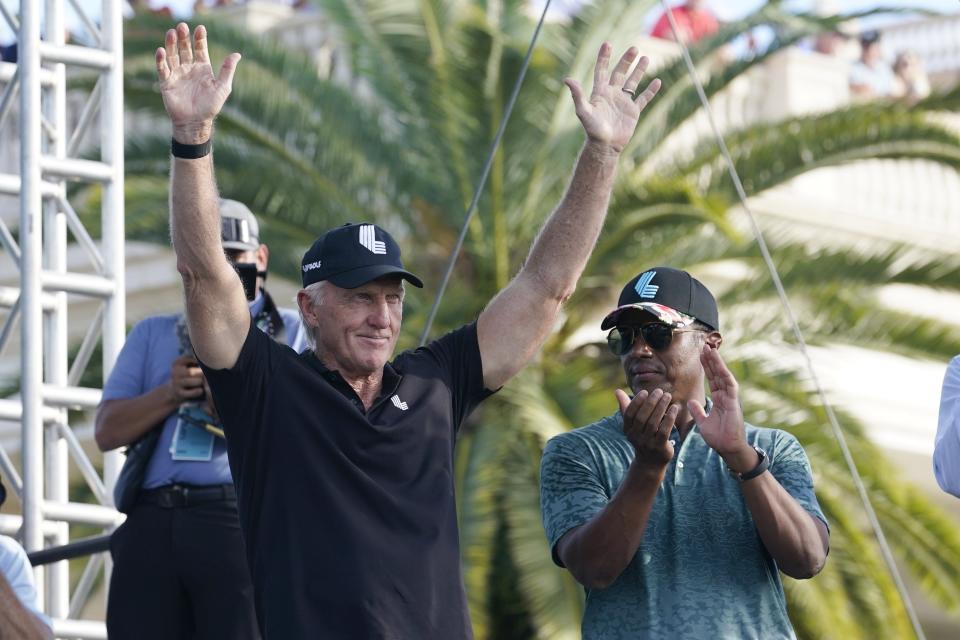 LIV Golf CEO Greg Norman, left, waves as Majed Al-Sorour, CEO of Golf Saudi, looks on during a ceremony after the final round of the LIV Golf Team Championship at Trump National Doral Golf Club this past Sunday.