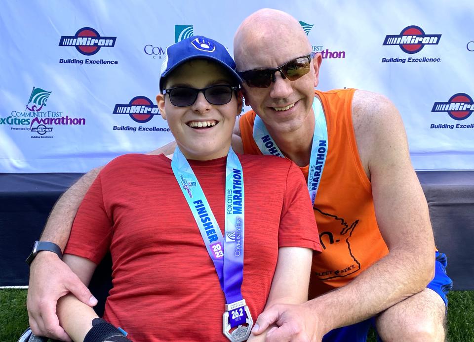 Gabriel Langlois and his father Daniel pose after completing the Community First Fox Cities Marathon Presented By Miron Construction on Sunday. Gabriel has spina bifida and uses a racing wheelchair.