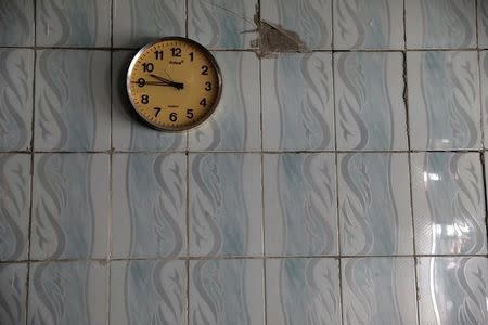 A clock hangs on a wall at an abandoned restaurant in western Mosul, Iraq, April 6, 2017. REUTERS/Andres Martinez Casares/Files