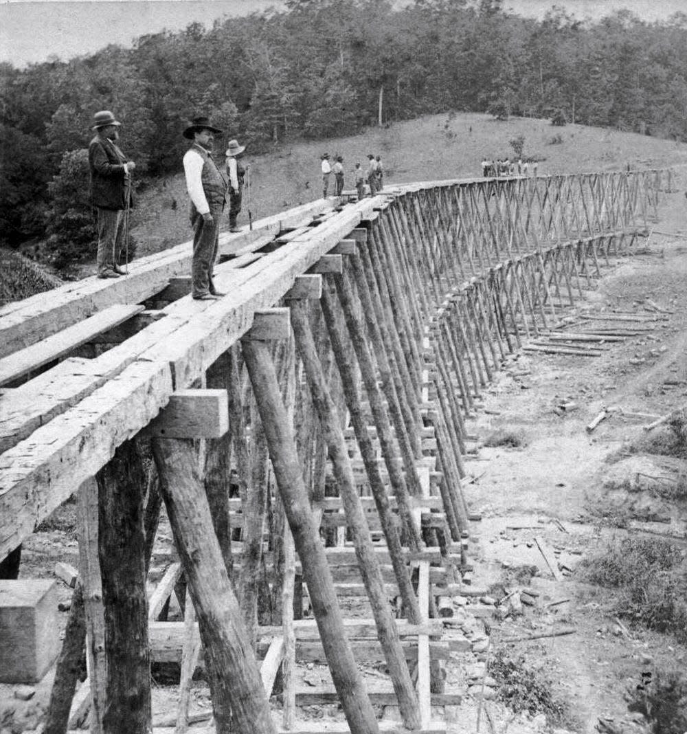Western North Carolina Railroad workers construct a trestle across Gashes Creek in the summer of 1880. It was about this time and shortly after that Asheville railroad entrepreneur William Best was involved in a struggle for control of the railroads in Western North Carolina.