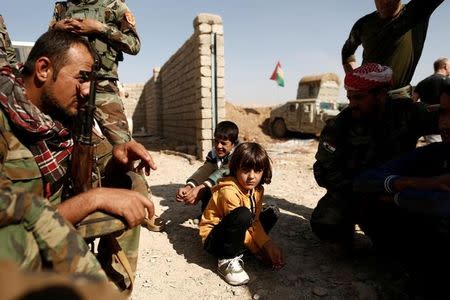 Children who just fled Abu Jarbuah village sit at a Kurdish Peshmerga position between two front lines near Bashiqa, east of Mosul, Iraq October 29, 2016. REUTERS/Zohra Bensemra