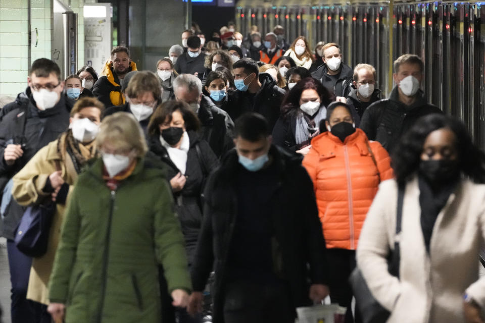 Commuters wearing face masks to protect against the coronavirus as they arrives at the public transport station Brandenburger Tor in central Berlin, Germany, Friday, Nov. 12, 2021. Germany battles a fourth wave of the coronavirus with high number of infections in the recent days. (AP Photo/Markus Schreiber)