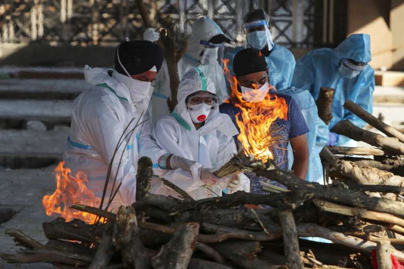 死亡病例湧入讓印度的火葬場不堪負荷，遺體與家屬只得排隊等候。（美聯社）