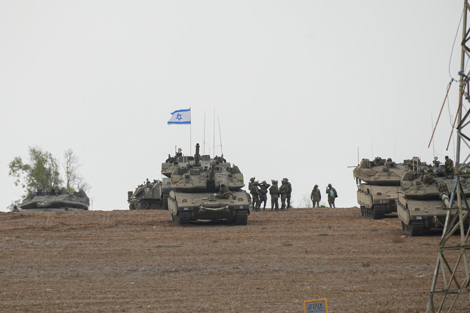 Israeli soldiers are seen in a staging ground near the Israeli Gaza border, southern Israel, Monday, Oct. 9, 2023. The militant Hamas rulers of the Gaza Strip carried out an unprecedented, multi-front attack on Israel at daybreak Saturday, firing thousands of rockets as dozens of Hamas fighters infiltrated the heavily fortified border in several locations, killing hundreds and taking captives. Palestinian health officials reported scores of deaths from Israeli airstrikes in Gaza. (AP Photo/Ohad Zwigenberg)