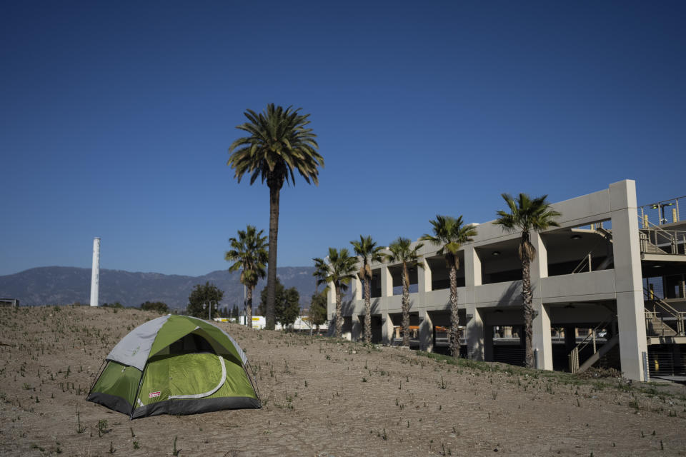 Una casa de campaña de un indigente junto a una estructura vacía en San Bernardino, California, el jueves 8 de diciembre de 2022. (AP Foto/Jae C. Hong)