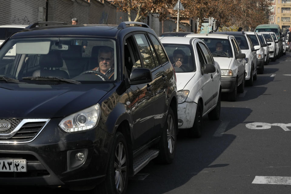Cars line up outside a gas station in Tehran, Iran, Monday, Dec. 18, 2023. Nearly 70% of Iran's gas stations went out of service on Monday following possible sabotage — a reference to cyberattacks, Iranian state TV reported. (AP Photo/Vahid Salemi)