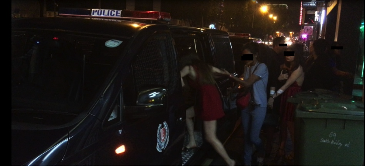 Suspects being moved into a police vehicle. (PHOTO: Singapore Police Force)