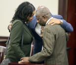 Nichelle and David Etute pray as jury deliberations begin in former Virginia Tech football player Isimemen David Etute's trial in Montgomery County Circuit Court in Christiansburg, Va., Friday May 27 2022. Etute is accused of fatally beating Jerry Smith, 40 in May 2021, a man he met on an online dating site and had initially believed to be a woman. (Matt Gentry/The Roanoke Times via AP)