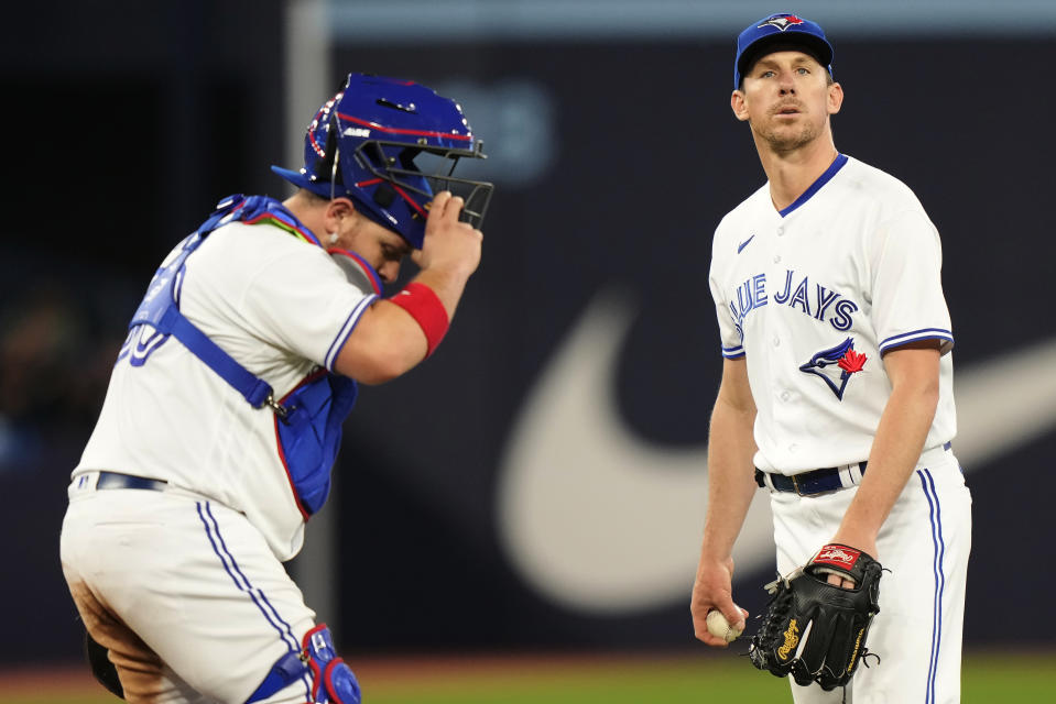 Toronto Blue Jays catcher Alejandro Kirk visits starting pitcher Chris Bassitt on the mound during the fifth inning of the team's baseball game against the New York Yankees on Wednesday, May 17, 2023, in Toronto. (Frank Gunn/The Canadian Press via AP)