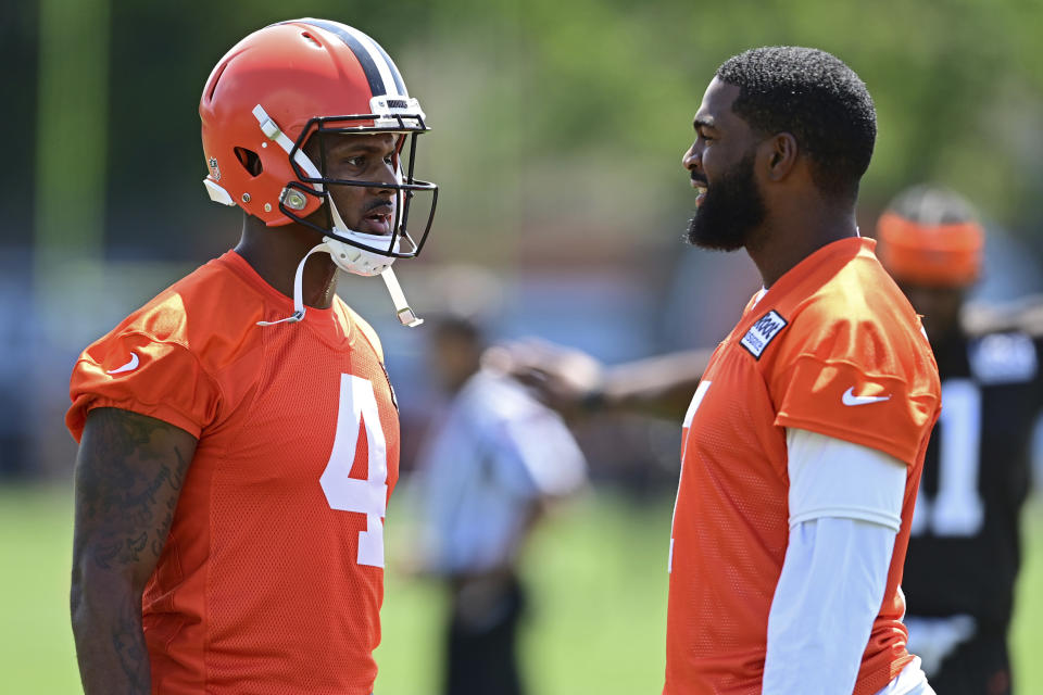 Cleveland Browns quarterbacks Deshaun Watson, left, and Jacoby Brissett talk before an NFL football practice in Berea, Ohio, Saturday, July 30, 2022. (AP Photo/David Dermer)