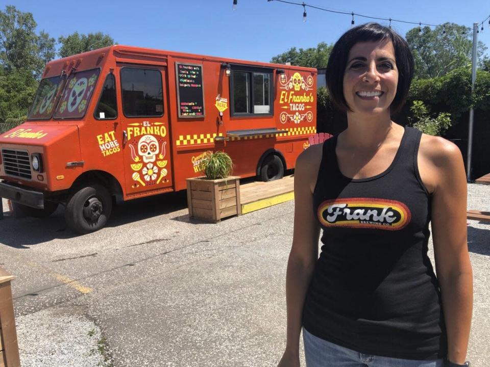 Melissa Ventura of the Frank Brewing Co., stands in front of their taco truck in their beer garden just added this year. (Dale Molnar/CBC News - image credit)
