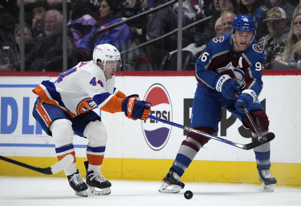 Colorado Avalanche right wing Mikko Rantanen, right, passes the puck as New York Islanders center Jean-Gabriel Pageau defends during the second period of an NHL hockey game Tuesday, Jan. 2, 2024, in Denver. (AP Photo/David Zalubowski)