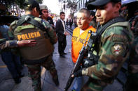 Peruvian police escort detainees after seized more than two tonnes of cocaine hidden in packages of asparagus destined for Amsterdam at police headquarters in Lima, Peru, January 12, 2017. REUTERS/Mariana Bazo