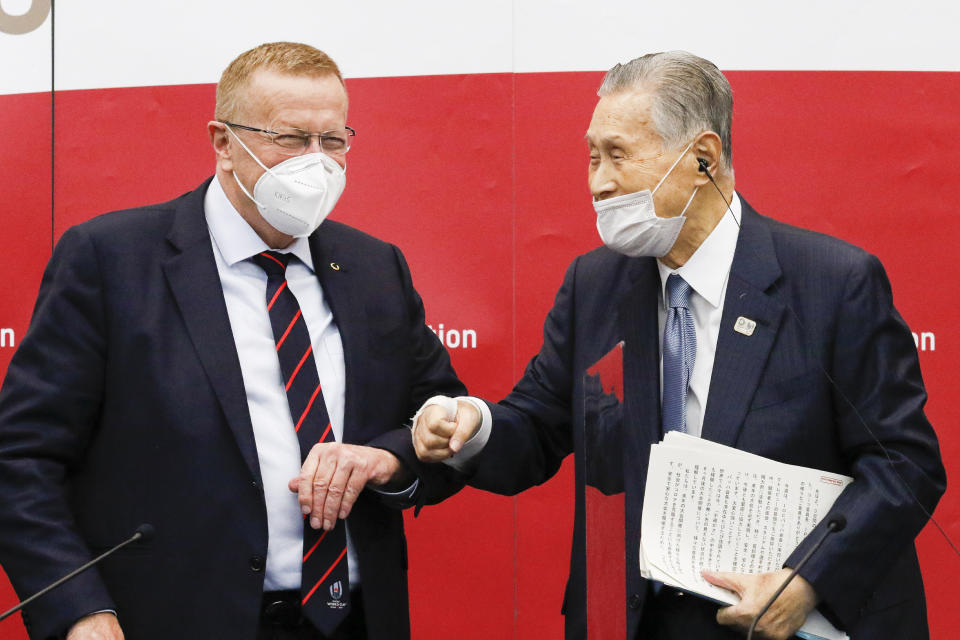 Yoshiro Mori, president of the Tokyo 2020 organizing committee, right, greets John Coates, chairman of the Coordination Commission for the Tokyo 2020 Olympics, during a press conference in Tokyo, Wednesday, Nov. 18, 2020. (Rodrigo Reyes Marin/Pool Photo via AP)