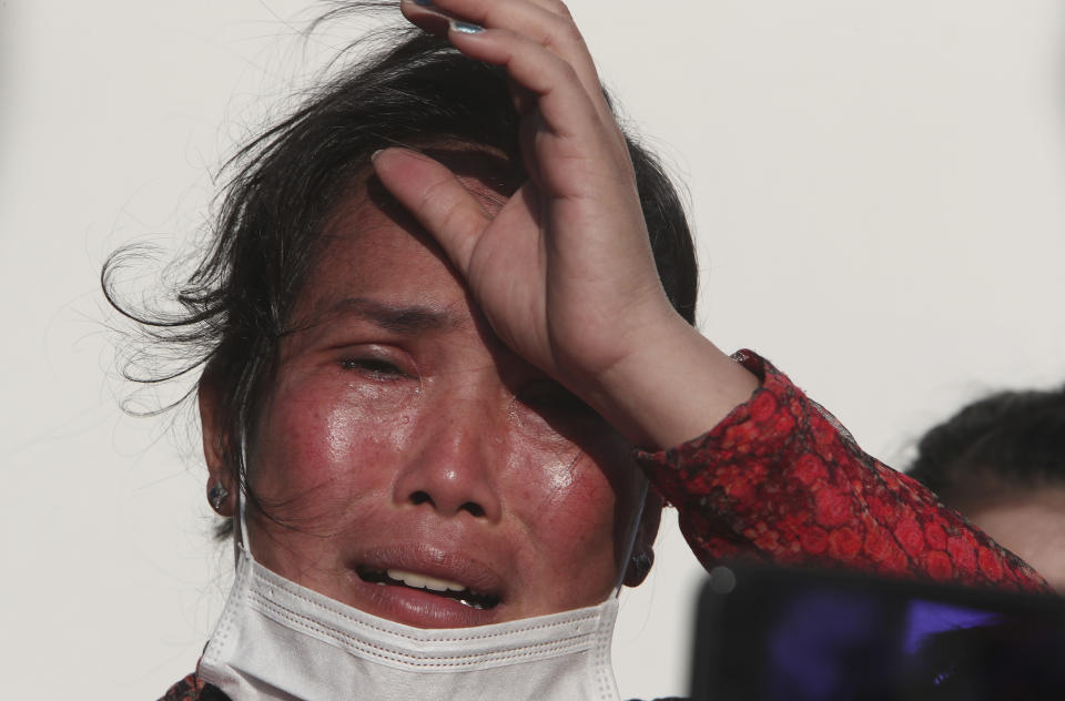 Prum Chenda, wife of a jailed former opposition activist, cries as she talks to the press about her husband's history in front of the Phnom Penh Municipal Court, in Phnom Penh, Cambodia, Thursday, Jan. 14, 2021. The trial of more than 60 critics and opponents of the Cambodian government charged with treason and other offenses for taking part in nonviolent political activities resumed Thursday, with rights advocates skeptical that justice is being served. (AP Photo/Heng Sinith)