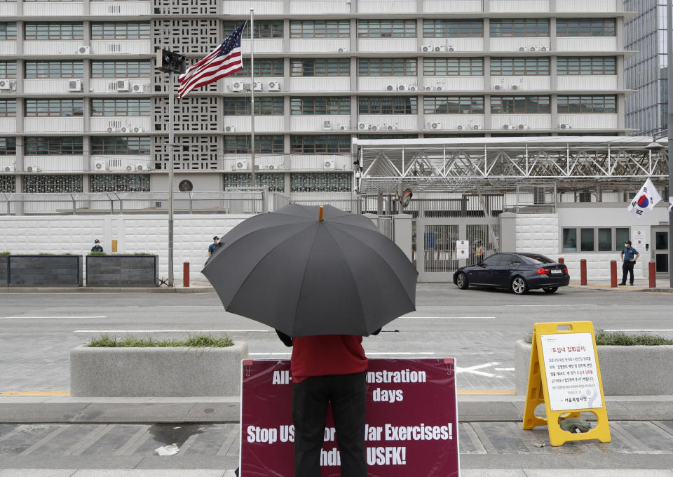 A man stands with a banner to oppose the joint military exercises between South Korea and the United States near the US Embassy in Seoul, South Korea, Sunday, Aug. 16, 2020. The countries will begin their annual joint military exercises this week, Seoul’s Joint Chiefs of Staff said Sunday. But a spreading coronavirus outbreak has apparently forced the allies to scale back an already low-key training program mainly involving computer-simulated war scenarios. (AP Photo/Lee Jin-man)