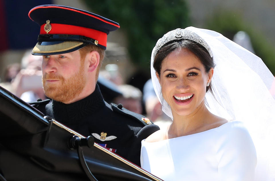 TOPSHOT - Britain's Prince Harry, Duke of Sussex and his wife Meghan, Duchess of Sussex begin their carriage procession in the Ascot Landau Carriage after their wedding ceremony at St George's Chapel, Windsor Castle, in Windsor, on May 19, 2018. (Photo by Gareth Fuller / POOL / AFP)        (Photo credit should read GARETH FULLER/AFP via Getty Images)