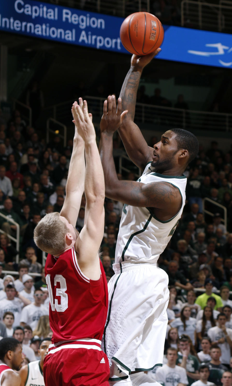 Michigan State's Branden Dawson, right, shoots over Indiana's Austin Etherington (13) during the second half of an NCAA college basketball game, Tuesday, Jan. 21, 2014, in East Lansing, Mich. Michigan State won 71-66. (AP Photo/Al Goldis)