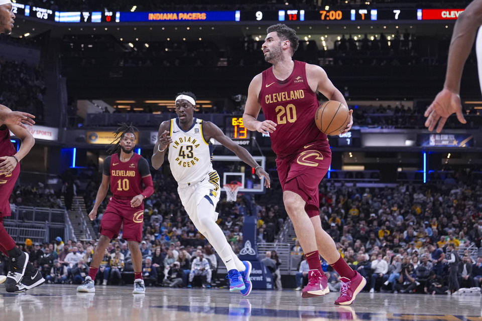 Cleveland Cavaliers forward Georges Niang (20) drives past Indiana Pacers forward Pascal Siakam (43) during the first half of an NBA basketball game in Indianapolis, Monday, March 18, 2024. (AP Photo/Michael Conroy)