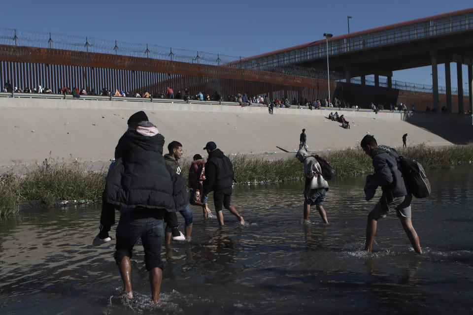 Migrantes se acercan al muro fronterizo desde Ciudad Juárez, México, el miércoles 21 de diciembre de 2022. (AP Foto/Christian Chavez)