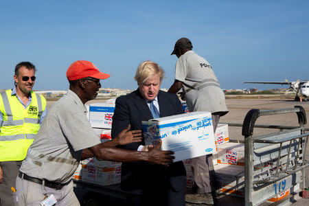 Britain's Foreign Secretary Boris Johnson helps to load supplies for treating malnourished children affected by severe drought in Somalia onto a cargo plane at Mogadishu International Airport in Mogadishu, Somalia March 15, 2017. REUTERS/Karel Prinsloo/UNICEF/Handout via REUTERS