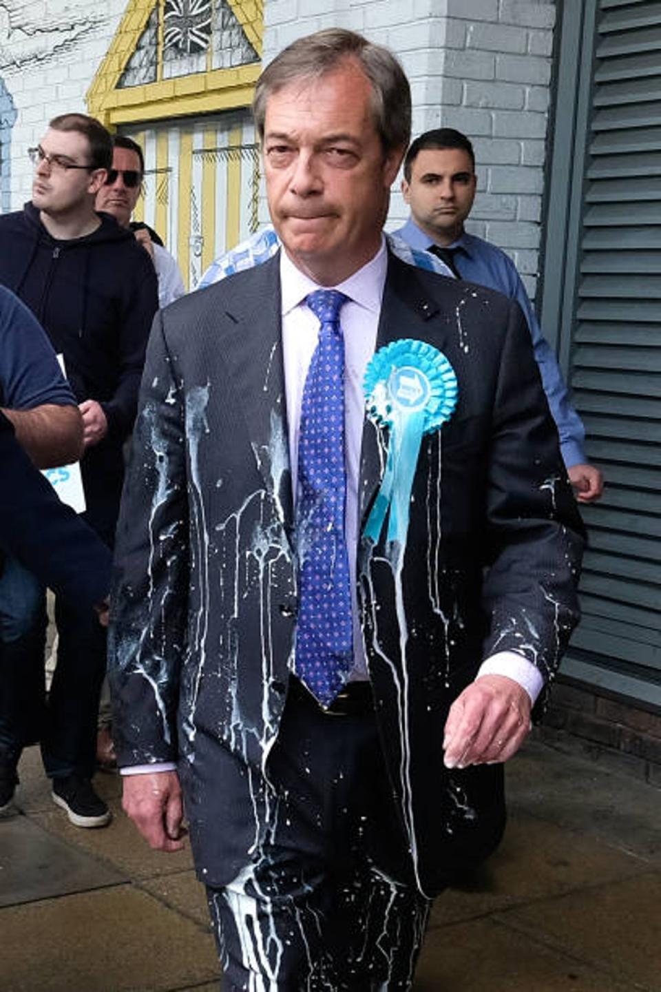 Brexit Party leader Nigel Farage is escorted to a car after having what is thought to be a milkshake thrown over him as he visits Northumberland Street in Newcastle upon Tyne during a whistle-stop UK tour on May 20, 2019 (Ian Forsyth / Getty Images)