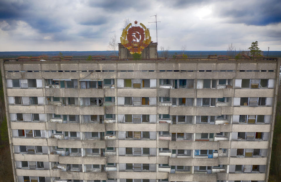 The rusty emblem of the Soviet Union is seen on the roof of an apartment building in the ghost town of Pripyat close to the Chernobyl nuclear plant, Ukraine, Thursday, April 15, 2021. The vast and empty Chernobyl Exclusion Zone around the site of the world’s worst nuclear accident is a baleful monument to human mistakes. Yet 35 years after a power plant reactor exploded, Ukrainians also look to it for inspiration, solace and income. (AP Photo/Efrem Lukatsky)