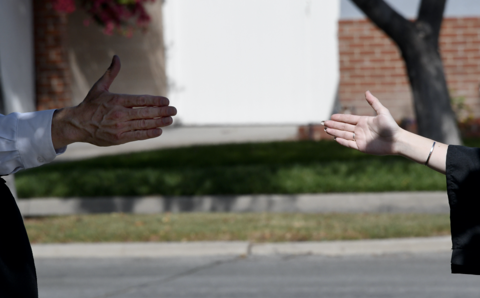 California State Fullerton Human Communication Studies dept. head Jon Bruschke with a social distance hand shake with graduate Kaitlin Buxton in Long Beach, California, on Saturday, May 23, 2020. (Photo: Keith Birmingham/MediaNews Group/Pasadena Star-News via Getty Images)