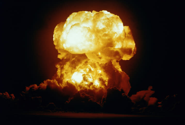 A large explosion with a mushroom cloud rising into the sky, resembling a nuclear detonation, against a dark background