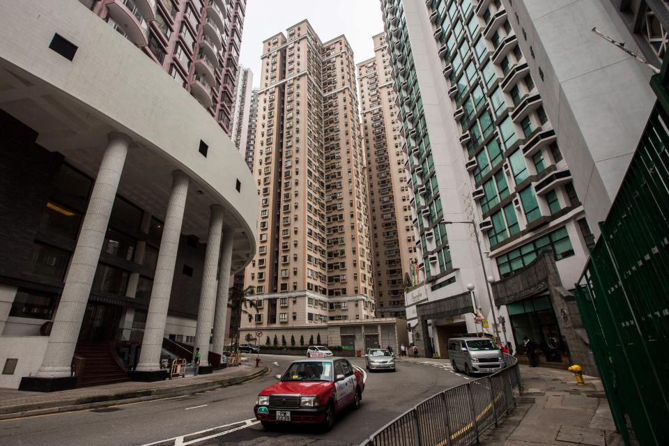 This picture taken on January 15, 2019, shows a taxi (C) drive past high density apartment blocks in the central district of Hong Kong. - The crammed financial hub regularly tops the list of cities with the least affordable housing in the world, with even cheap apartments out of the reach of most regular workers. (Photo by ISAAC LAWRENCE / AFP) / TO GO WITH: Hong Kong-property-economy-lifestyle, FOCUS by Jerome TAYLOR, Yan ZHAO        (Photo credit should read ISAAC LAWRENCE/AFP/Getty Images)