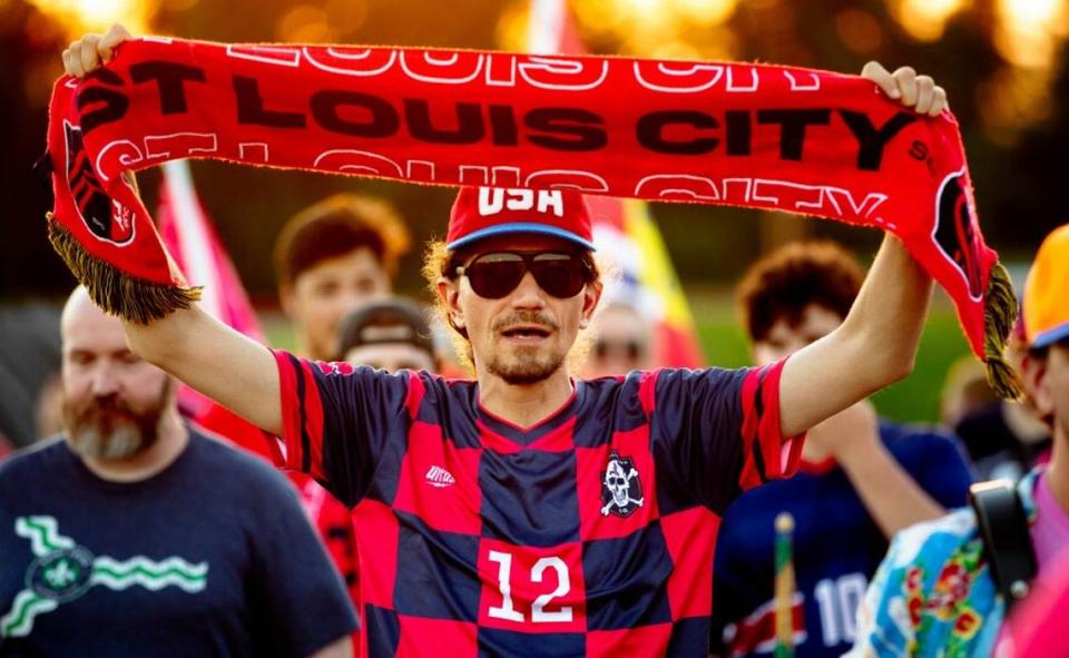 John Muhrer, 46, of Wildwood, Missouri, hoists up a St. Louis City S.C. scarf on Aug. 6 as fans march into a matchup between St. Louis City 2 and Chicago Fire 2 at Ralph Korte Stadium in Edwardsville.