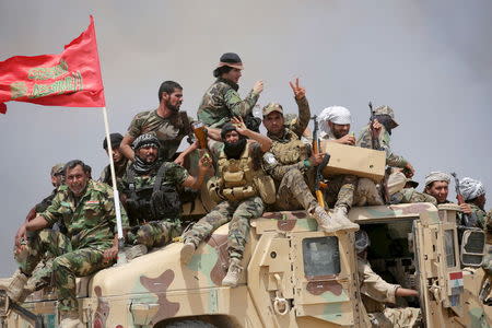 Iraq's Shi'ite paramilitaries ride in military vehicles in Nibai May 26, 2015. REUTERS/Stringer