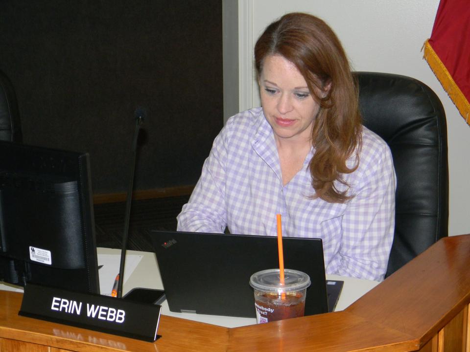 Oak Ridge Board of Education member Erin Webb works at a laptop at a school board meeting.