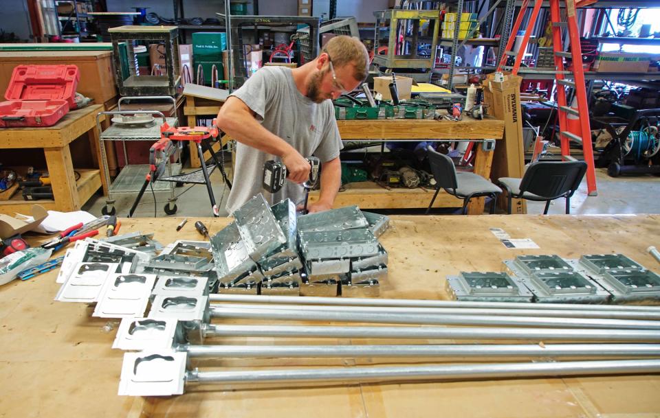 Brandon Van Horn, an electrician for Nickle Electrical Co. in Newark, puts together prefabricate electrical boxes out in the shop.